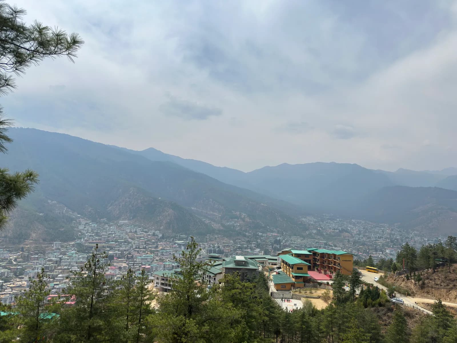 The green-roofed ELC buildings on the hillside above Thimphu, the valley beyond