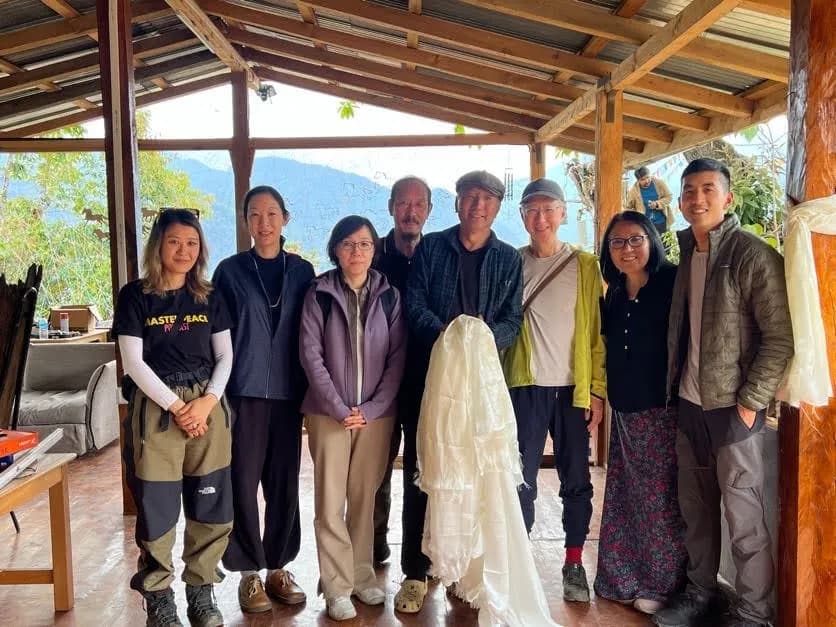 A group standing together under the timber roof of the art village in Punakha