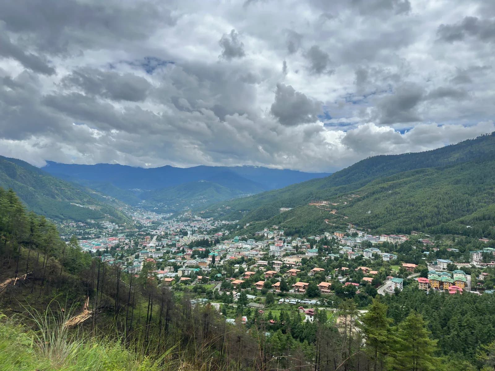 Monsoon cloud piled over the Thimphu valley, the town small in the middle distance