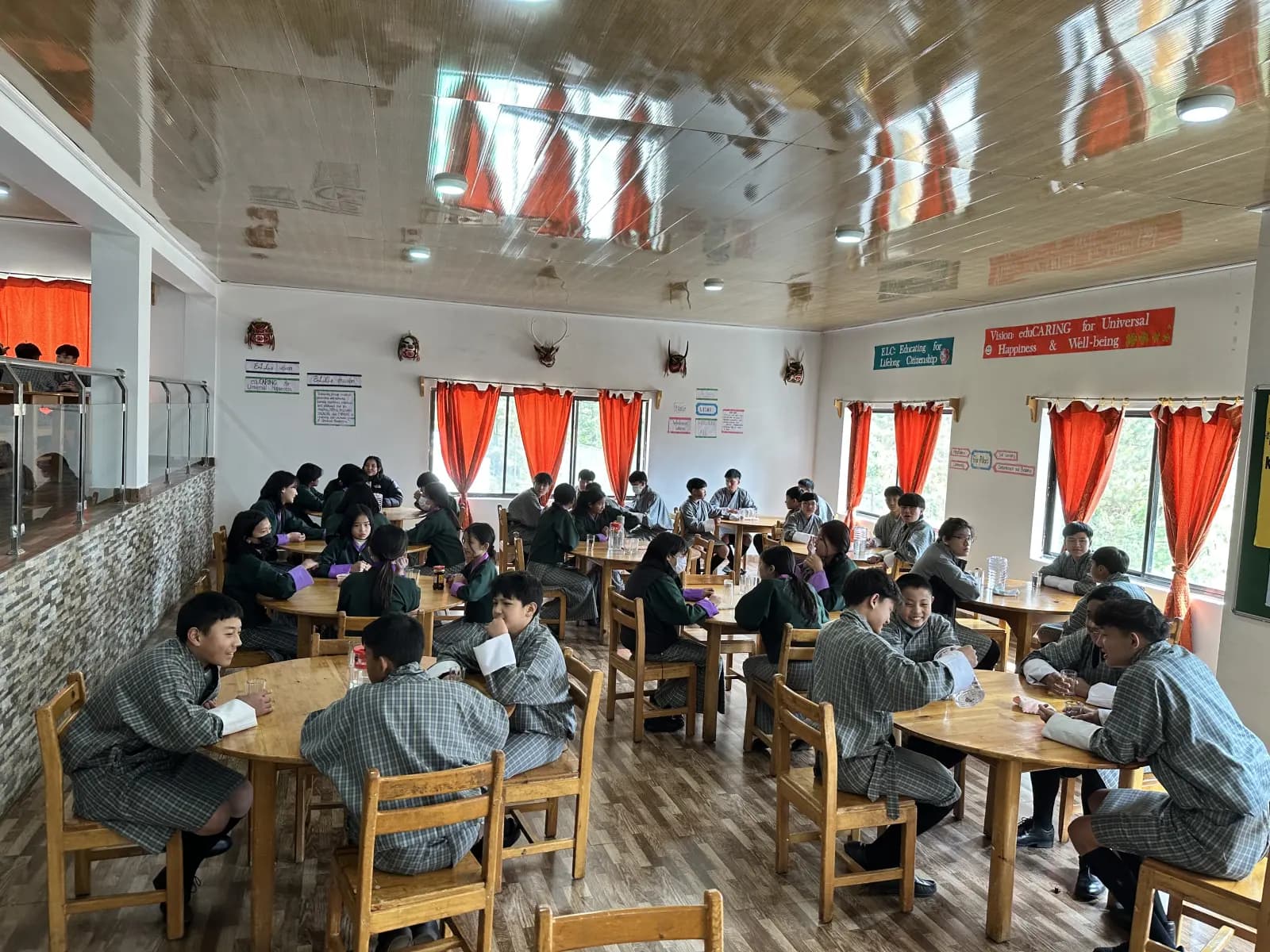 ELC students eating together at round tables in the school dining hall