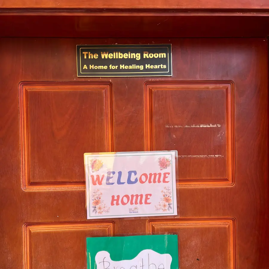 The wellbeing room door, its plaque reading The Wellbeing Room, A Home for Healing Hearts, with hand-made Welcome Home and Breathe notices below it